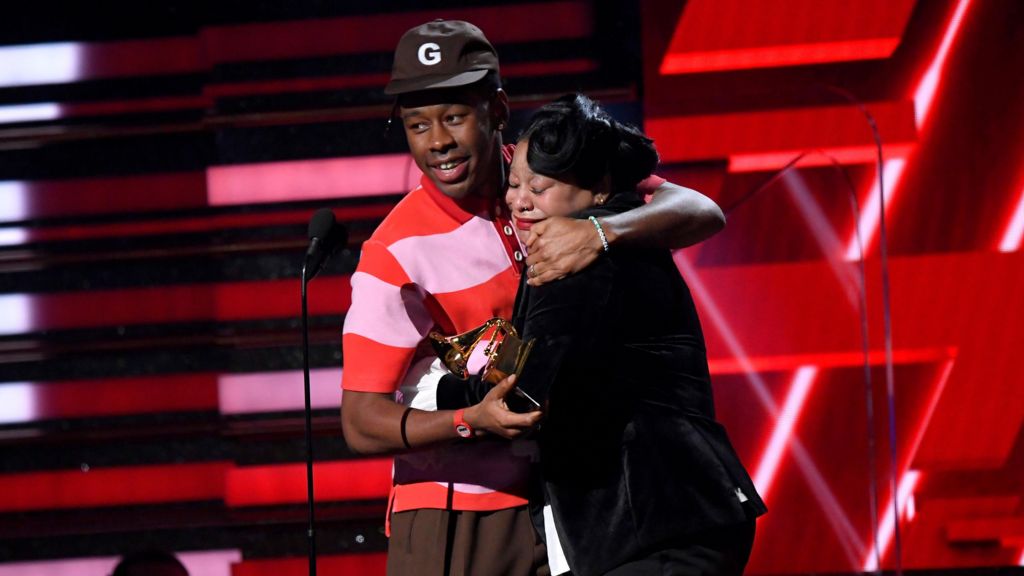 Tyler, The Creator hugging his mum on stage, while holding the Grammy for Best Rap Album.