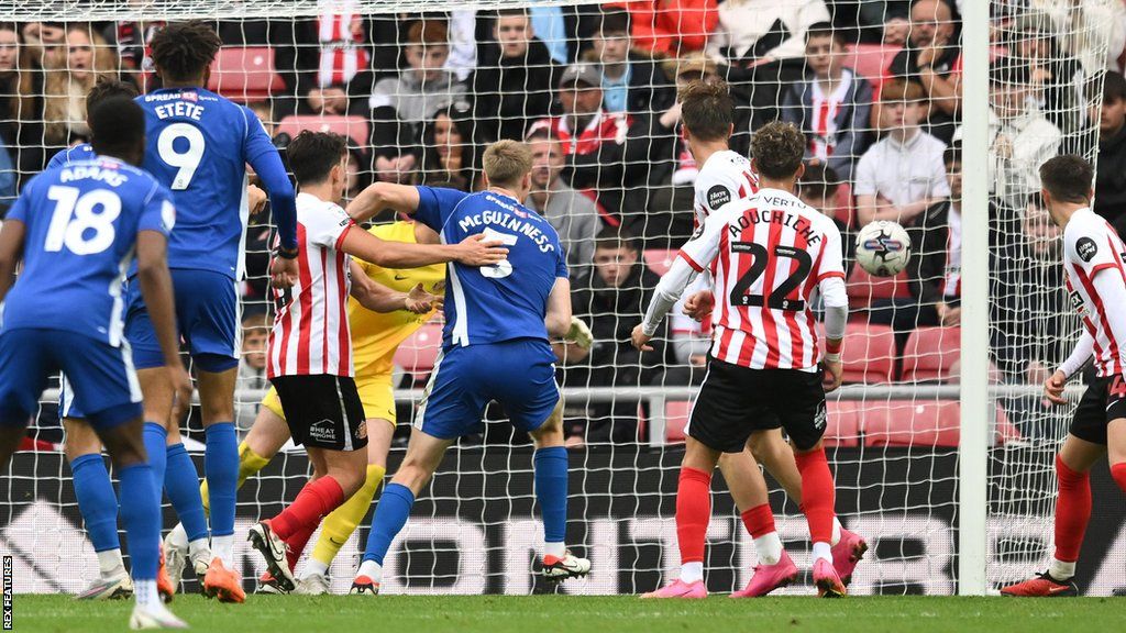 Mark McGuinness watches as his effort heads towards the net for Cardiff's winner