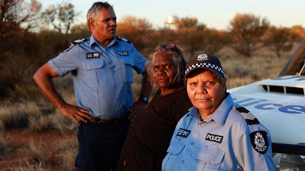 Two Indigenous police officers with Aboriginal elder