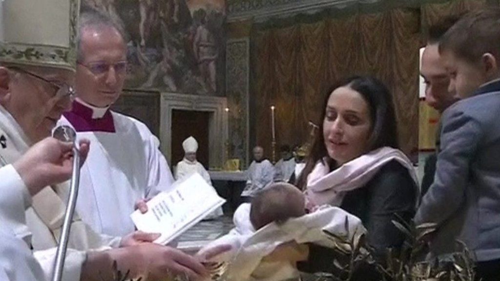 Pope Francis baptises a baby in the Sistine Chapel