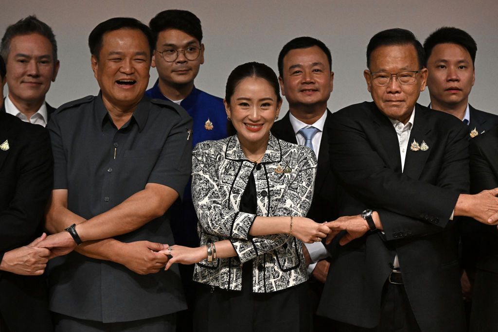 Paetongtarn Shinawatra (front C) joins hands with coalition party leaders at a press conference in Bangkok on August 15, 2024. 