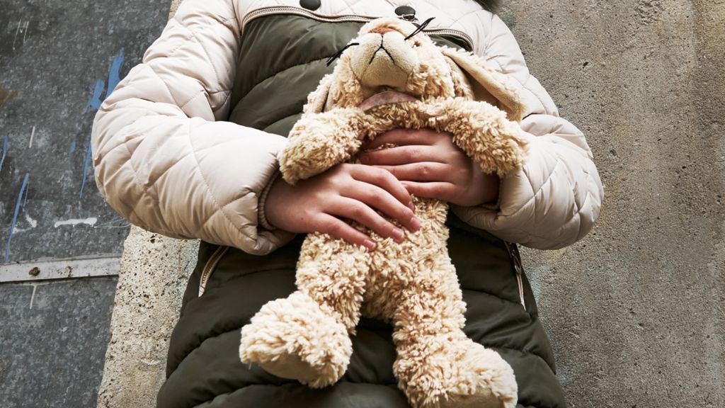 Child holding a cuddly toy