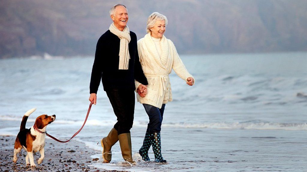 Man and woman on beach with dog