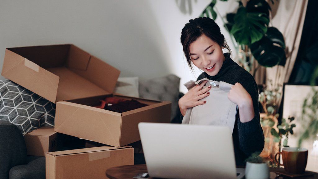 Stock image of someone unpacking a bit of online clothes shopping