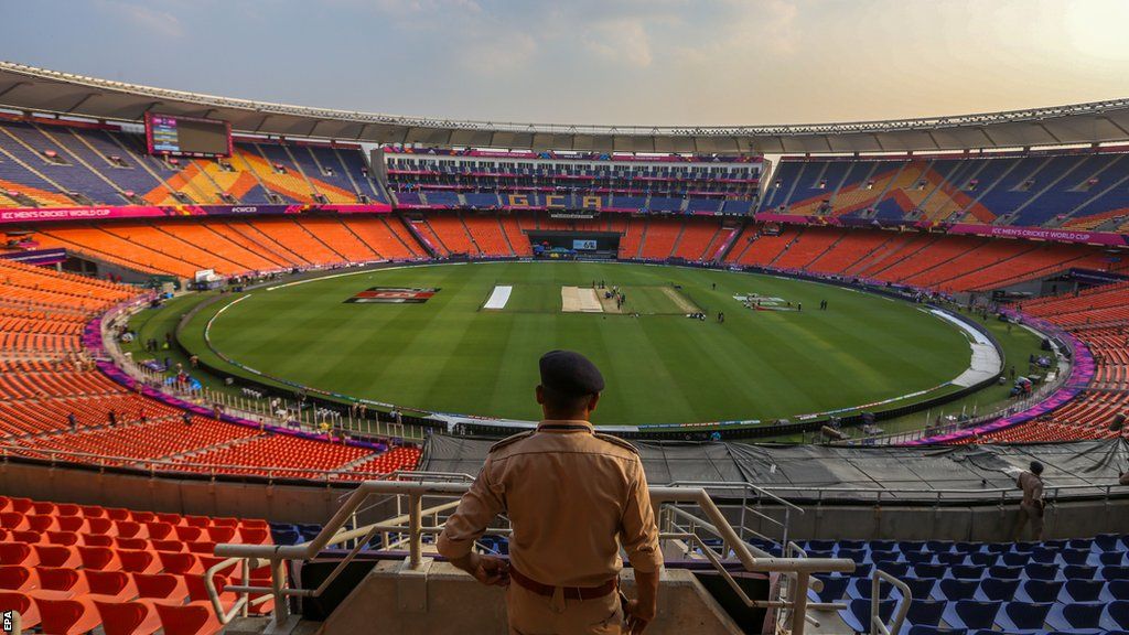 Security guard watches on as teams practice at Narendra Modi Stadium