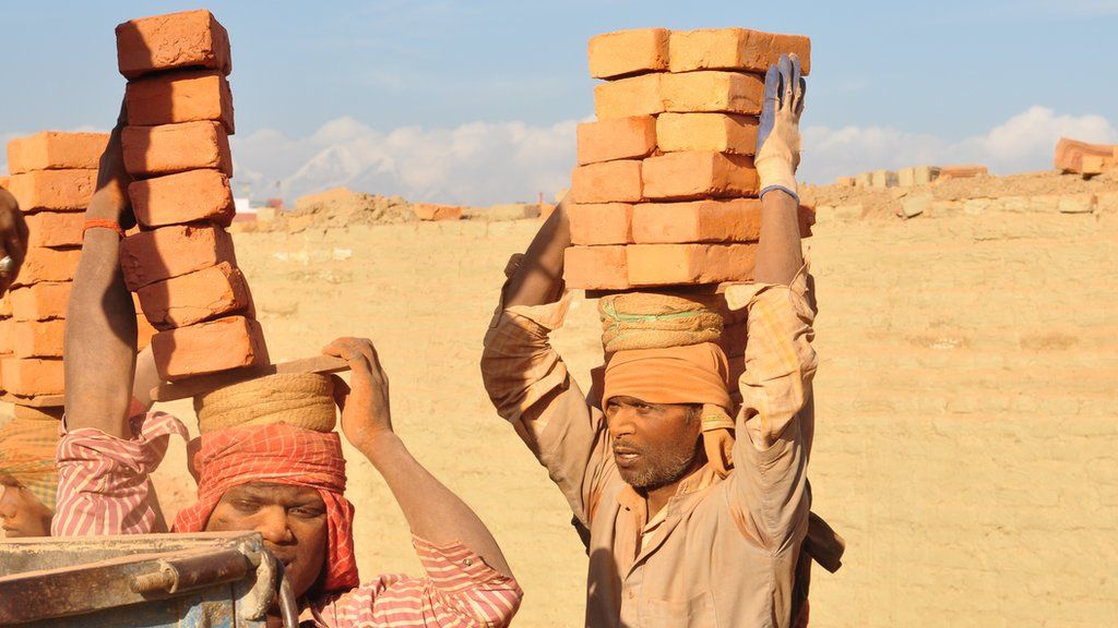 Workers carrying bricks