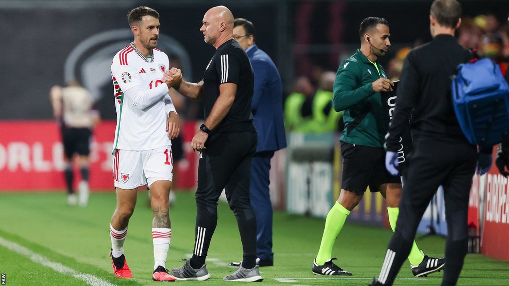 Aaron Ramsey shakes Rob Page's hand as he is substituted during Wales' win in Latvia