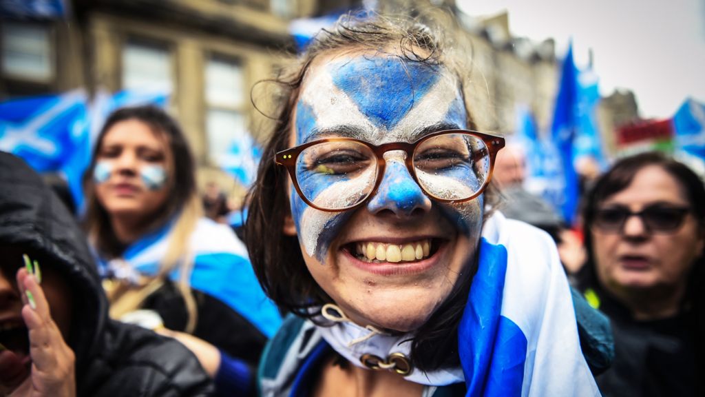 Young woman with Scotland flag painted on her face