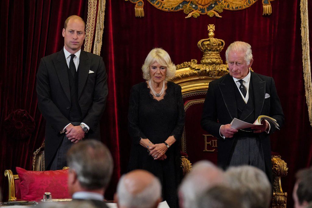 Britain's Prince William, Prince of Wales (L), Britain's Camilla, Queen Consort (C) listen as Britain's King Charles III