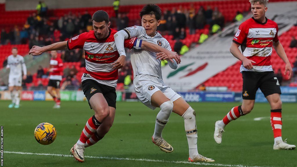 Newport forward Kiban Rai challenges Doncaster skipper Tommy Rowe