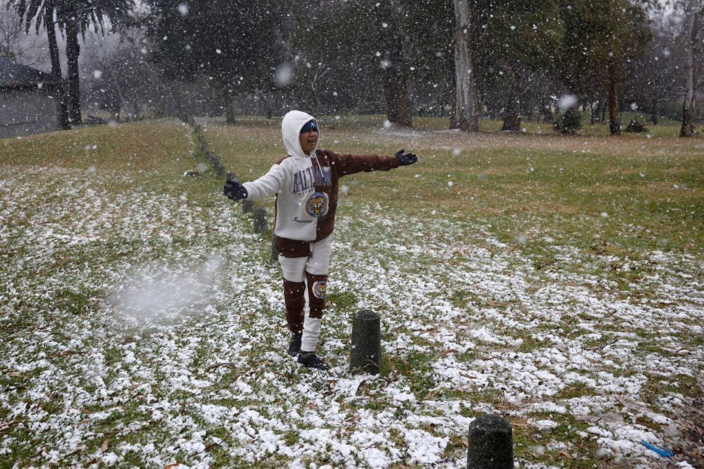 Gabriel Sussman gestures as snow falls in Zoo Lake Park in Johannesburg