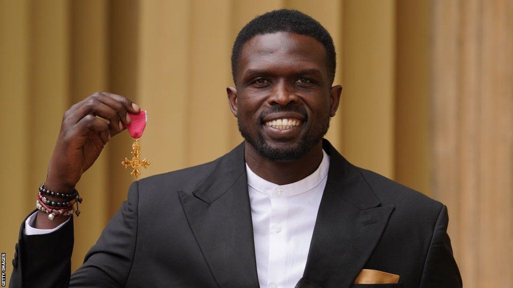 Luol Deng holds up his OBE