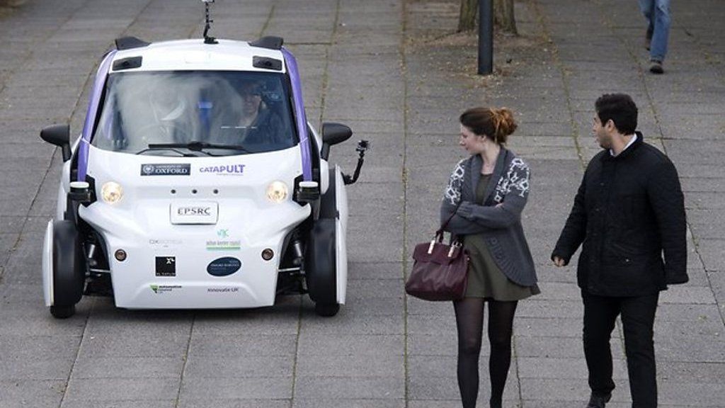 Pedestrians look at new driverless pod