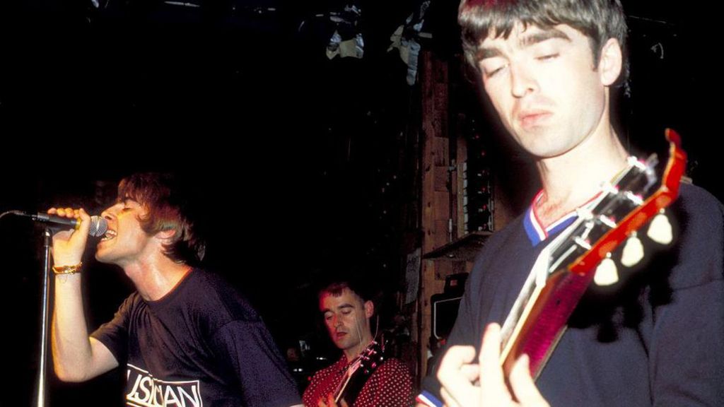 Oasis members Liam Gallagher, Noel Gallagher and Bonehead perform