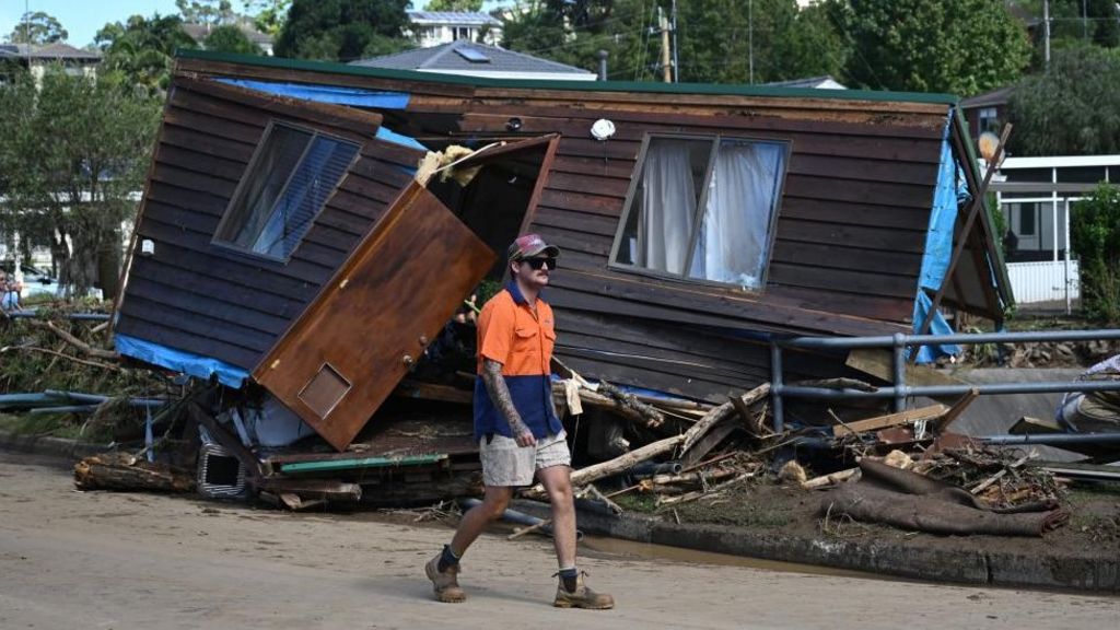 A man walks passed part of a house washed up onto Koloona Avenue in Mount Kiera, Wollongong, Australia, 6 April 2024.