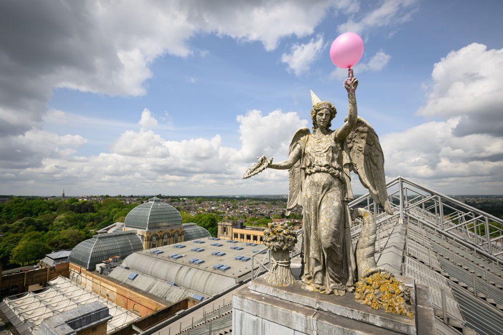 A balloon and party hat on the Angel of Plenty statue at Alexandra Palace, London