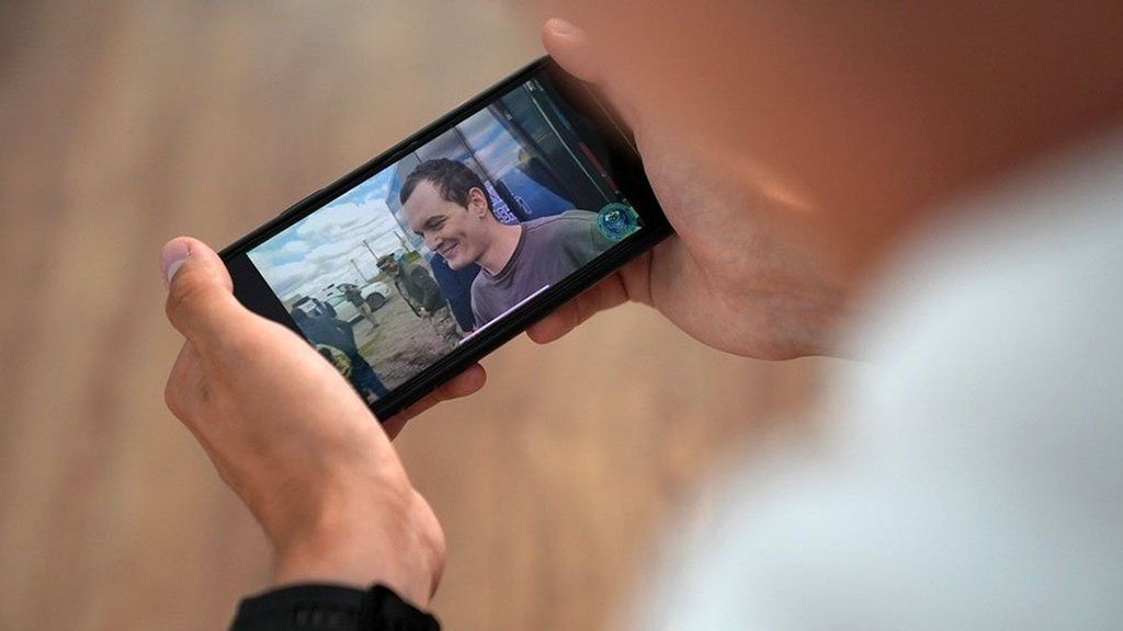 Телефон, показващ кадри на Artem Seredniak по време на освобождаването му