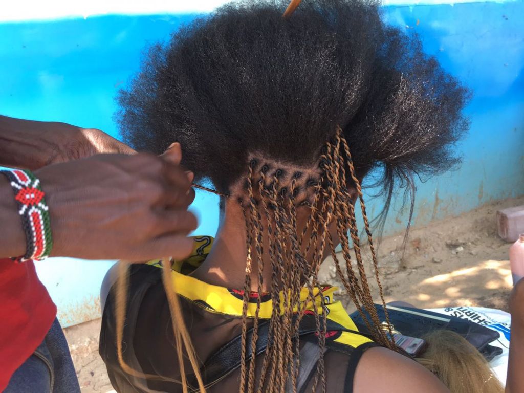 A woman gets her hair braided