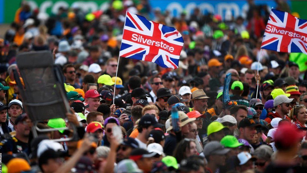 Fans at Silverstone wave flags with
