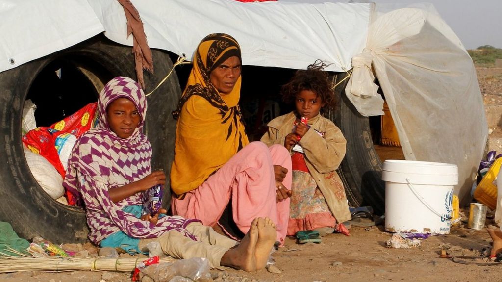 A woman and her daughters sit next to their hut at a makeshift camp for internally displaced people south of the Red Sea port city of Hudaydah, Yemen February 22, 2017