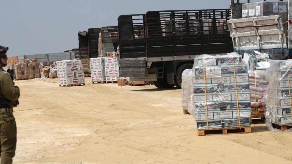 An Israeli soldier keeps watch as aid lorries to Gaza are checked at the Erez Crossing. Photo: 1 May 2024