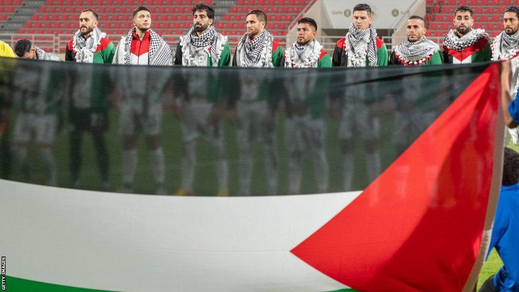 Palestine football team hold flag up