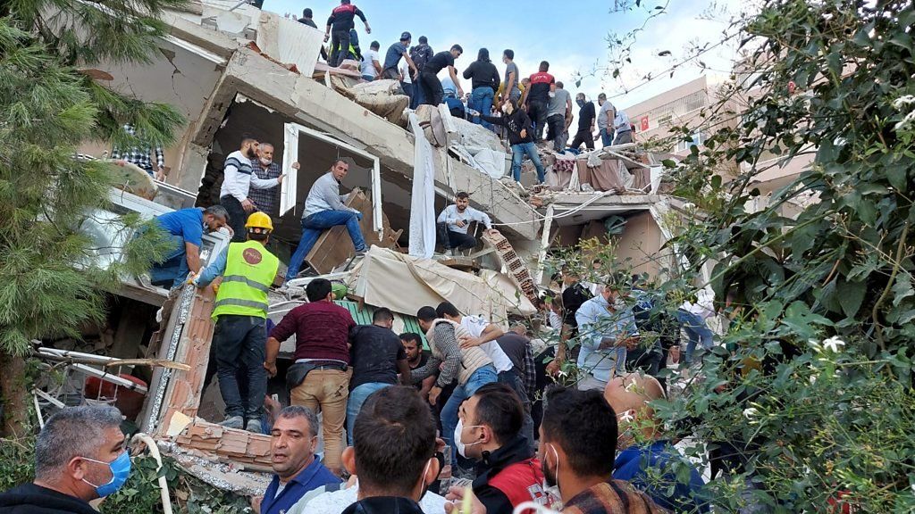 People moving rubble at a collapsed building