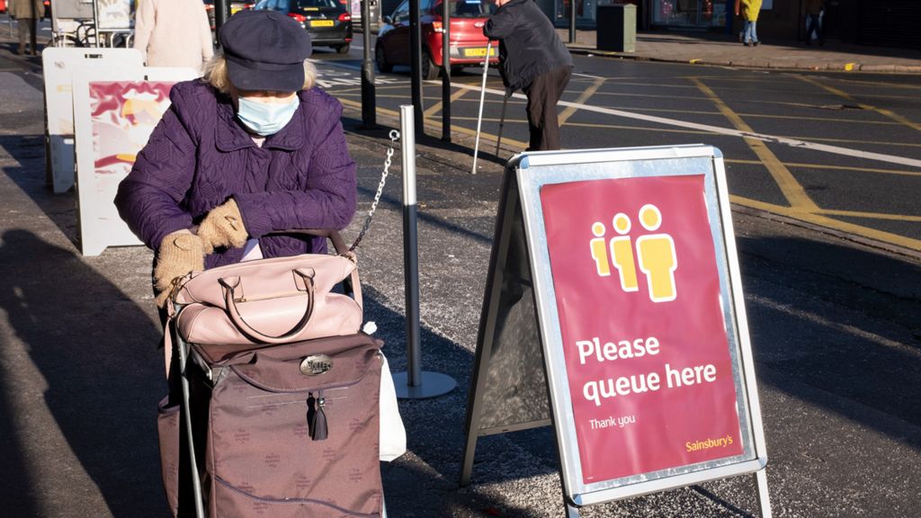 Elderly woman queuing outside a Birmingham supermarket, December 2020