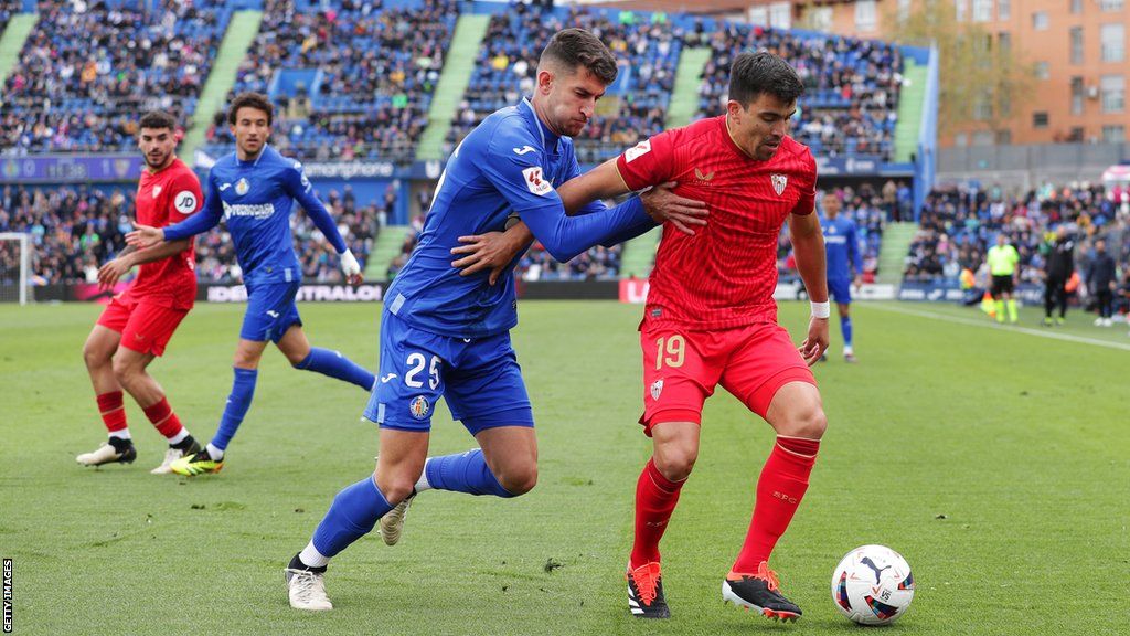 Sevilla's Marcos Acuna (right) battles for the ball v Getafe