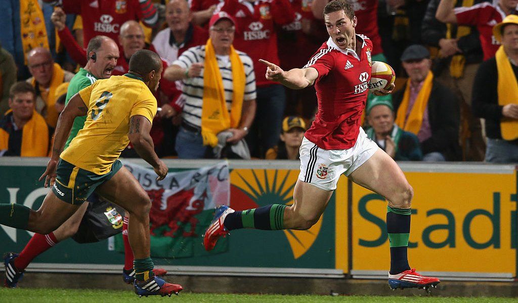 George North of the Lions taunts Will Genia as he breaks clear to score the first Lions try during the First Test