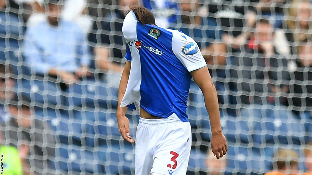 Blackburn defender Harry Pickering pulls his shirt over his head after being sent off