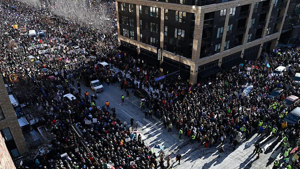 Thousands of protesters fill what can be seen from above of two wide city streets in downtown Minneapolis