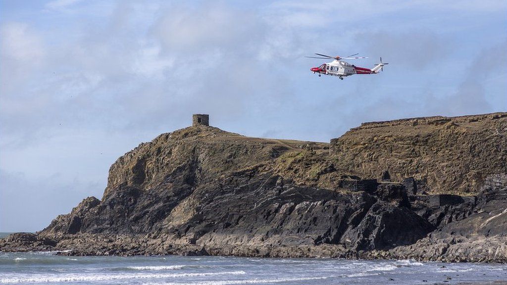Tîm achub yn ymateb i alwad ar ôl i fachgen fynd i drafferth yn y môr ger traeth Abereiddi yn Sir Benfro // A rescue helicopter responds to an emergency call near Abereiddy beach in Pembrokeshire