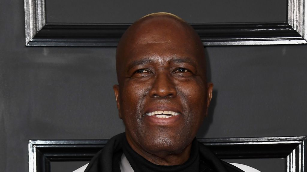 A close-up shot of Albert Mazibuko smiling with a black background behind him