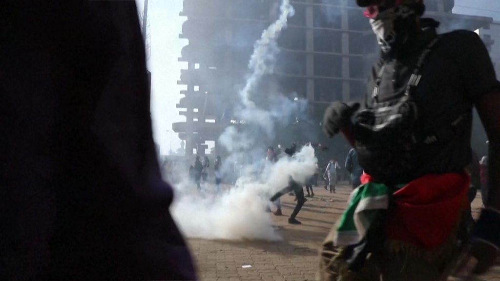 Protester throws back tear gas shell