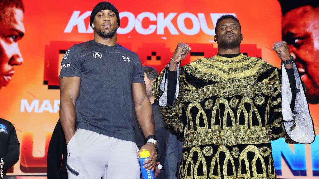 Anthony Joshua and Francis Ngannou pose for pictures side by side