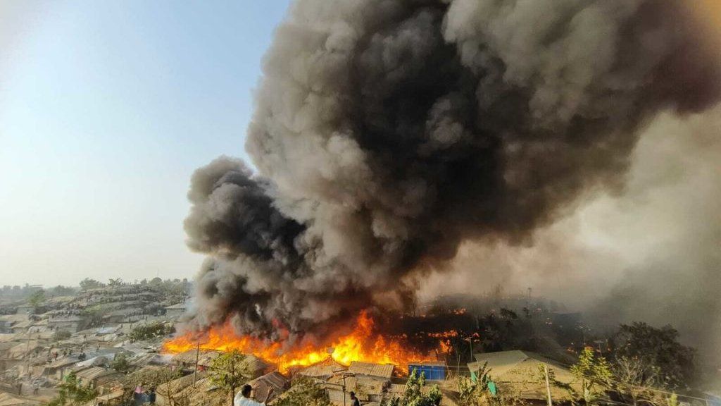 Wide shot of huge blaze at world's largest refugee camp in Bangladesh, with massive cloud of black smoke rising