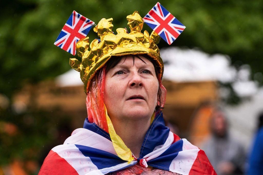 A woman wearing a poncho with flags in her crown