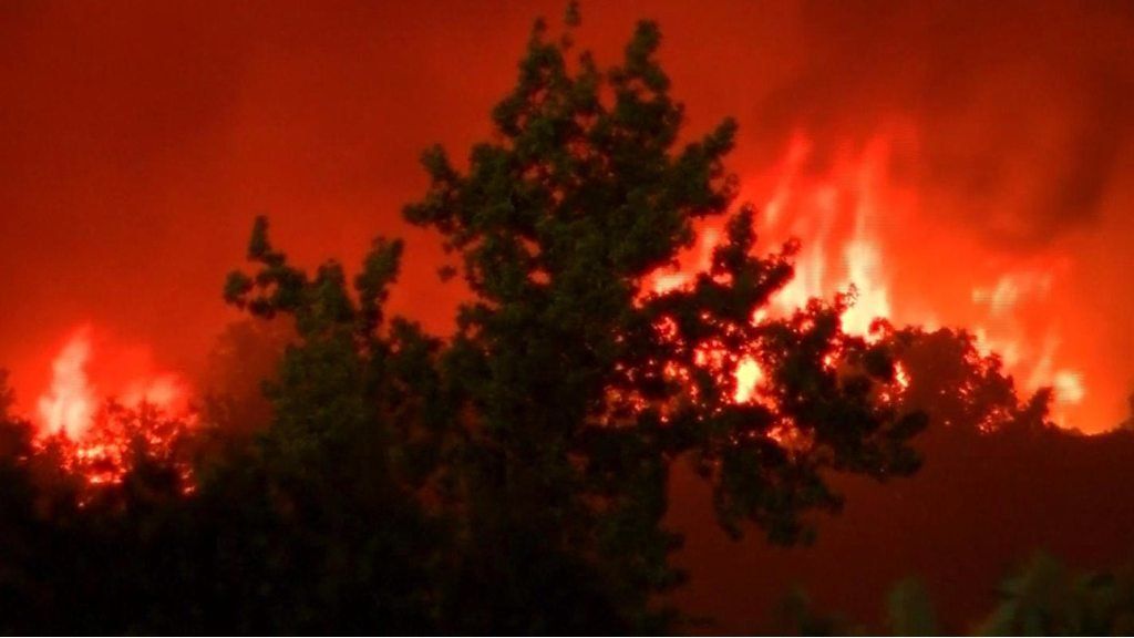 One person has died and others have fled their properties as a blaze rips through the city of Redding.