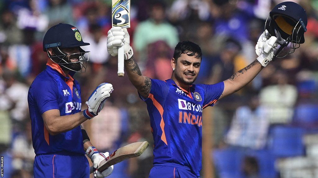 India batter Ishan Kishan raises his bat and helmet after hitting a double century against Bangladesh