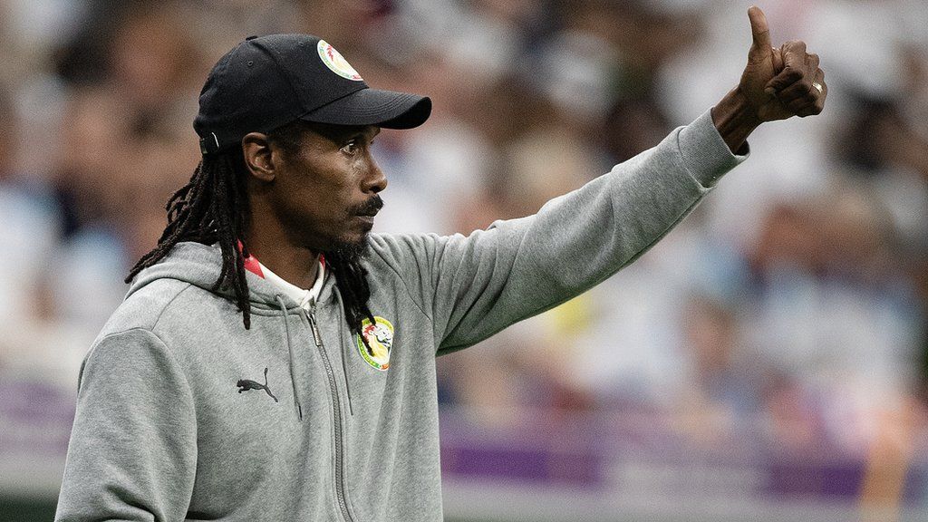 Senegal coach Aliou Cisse pictured with his thumbs up on the touchline