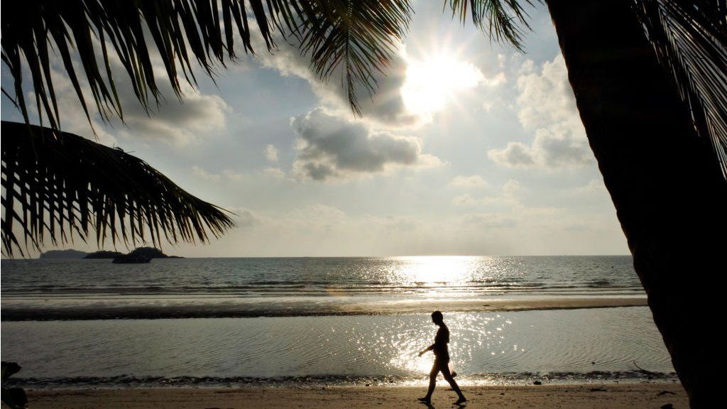 A person walks along the beach on Koh Chang Island in Trat province, 350 kms south of Bangkok during sunset