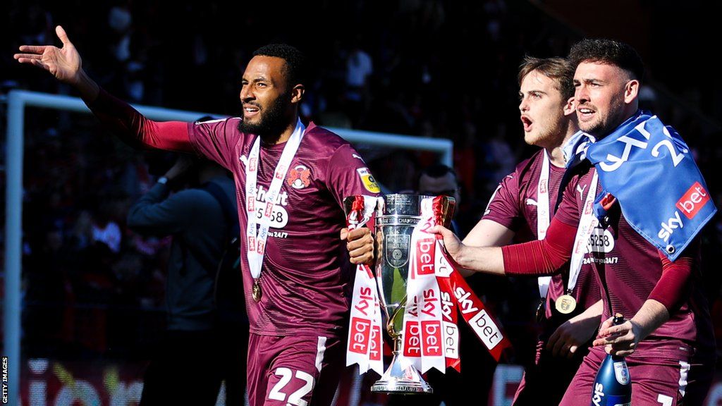 Leyton Orient players Lawrence Vigouroux, Rhys Byrne and Sam Sargeant celebrate with the League Two title