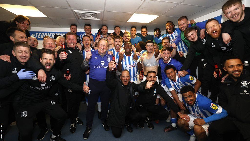 Huddersfield Town players and staff celebrate in the dressing room