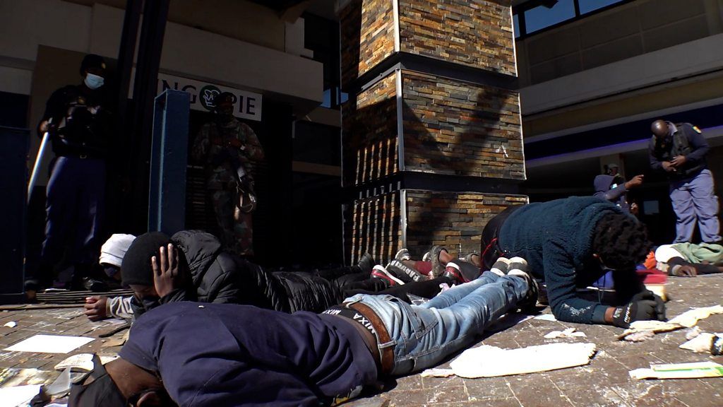 Men lying face-down in front of building