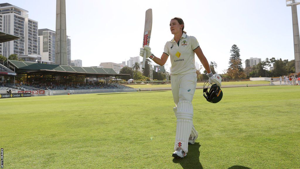 Australia's Annabel Sutherland raises her bat as she walks off