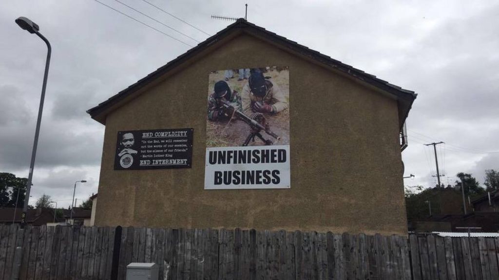 Councillor wants removal of image of masked men with guns on house wall