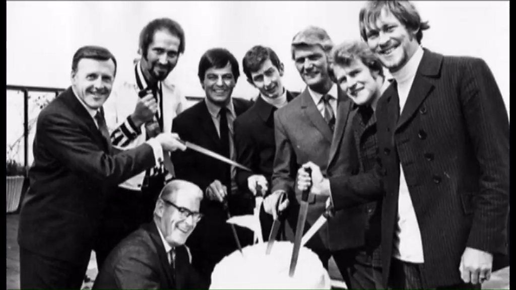 Cash (fourth from the left in the back row) is pictured cutting Radio 1's first birthday cake with fellow DJs