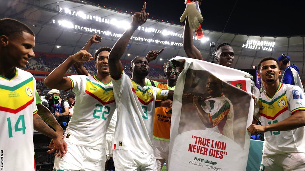 Senegal players with a banner of Papa Bouba Diop