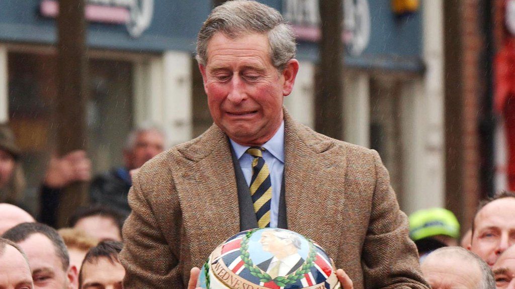 Prince Charles being lifted up holding the ceremonial ball before starting the ancient Royal Shrovetide Football game, in Ashbourne, Derbyshire